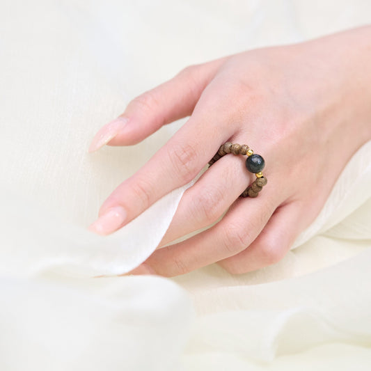 Détail de la perle centrale polie encadrée par des intercalaires métalliques dorés.