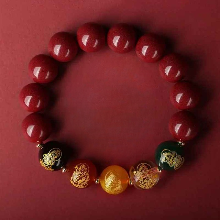 Focus sur les perles centrales décorées de symboles dorés, au cœur de la symbolique des cinq dieux.