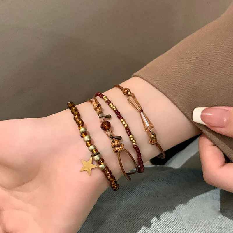 Bracelets boho superposés en perles marron, dorées et cristal lumineux.