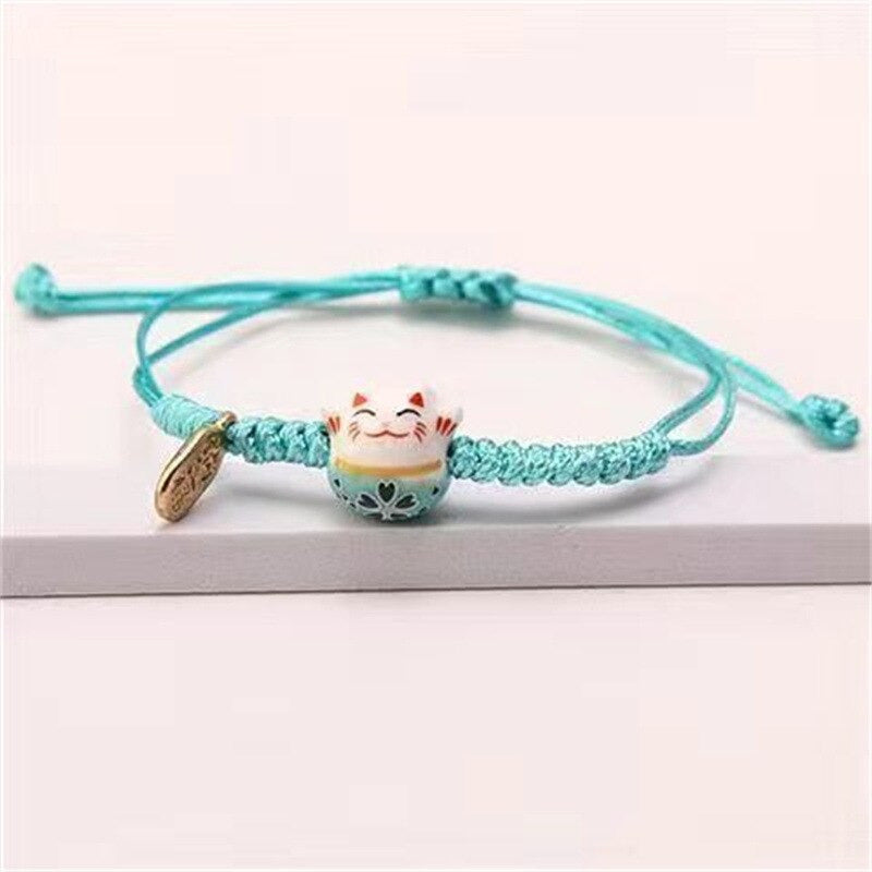 Bracelet macramé rouge avec pendentif Maneki Neko porte-bonheur.