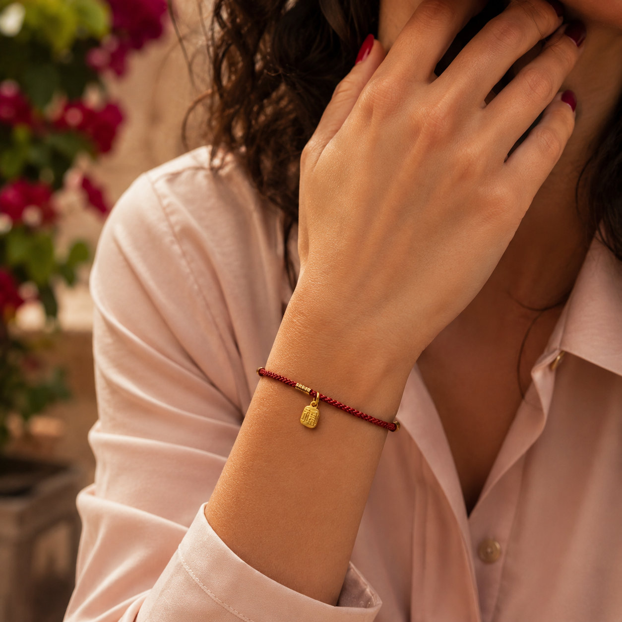 Bracelet rouge et doré au style minimaliste, conçu pour une allure discrète et symbolique. Le cordon tressé apporte une finition visuelle soignée.