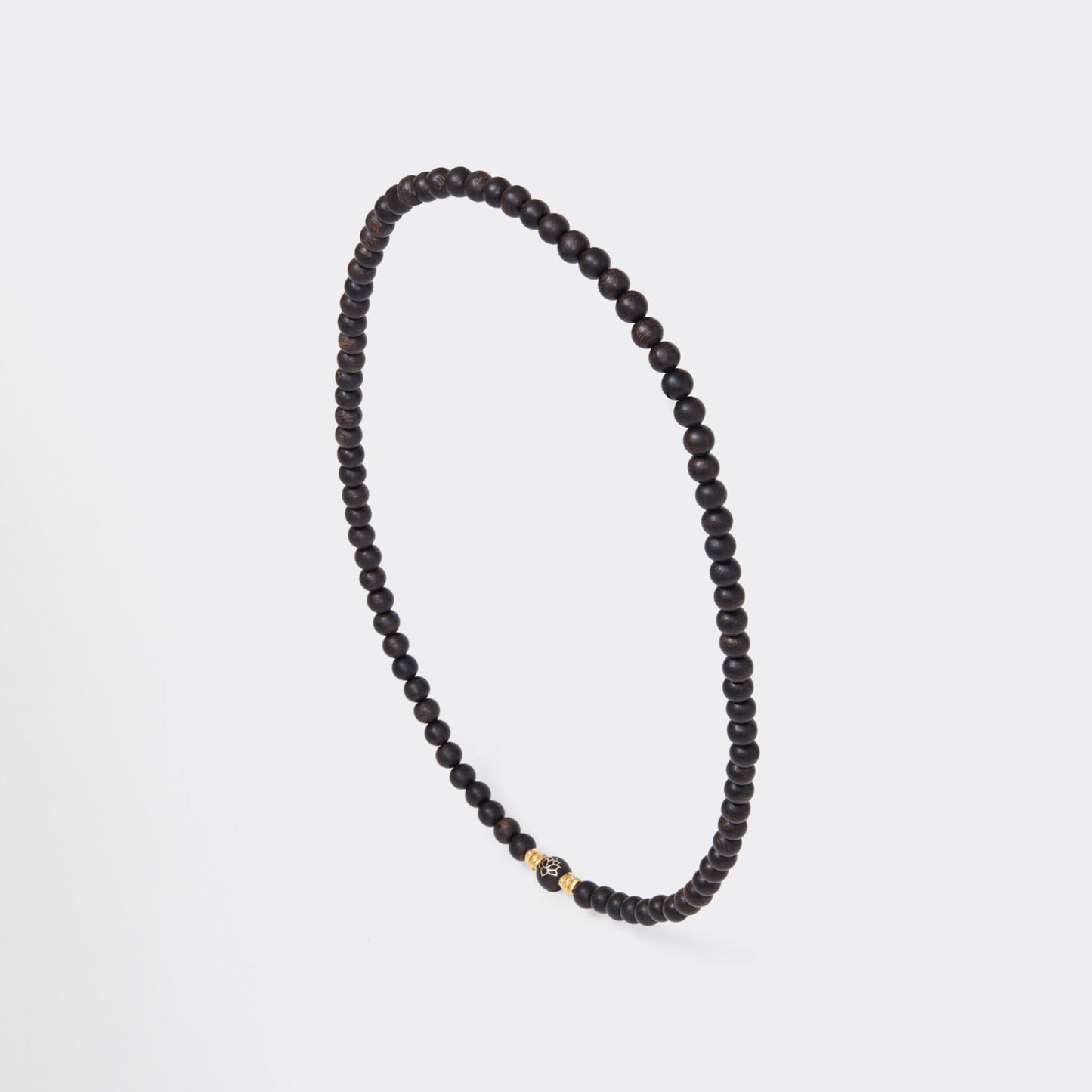 Vue latérale du collier révélant l’harmonie entre bois d’agar et éléments en or.
