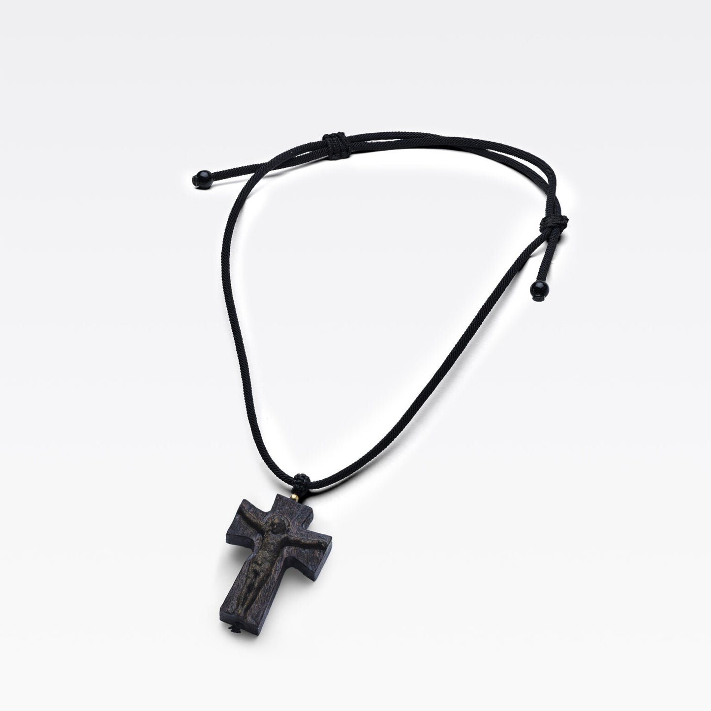 Grain naturel du bois d’agar révélé sur une croix sculptée.