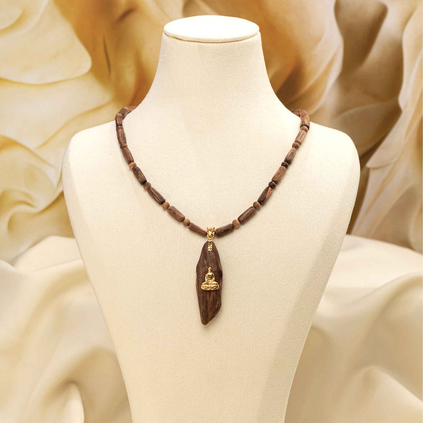 Pendentif en bois d’agar aux formes organiques et veinage visible.