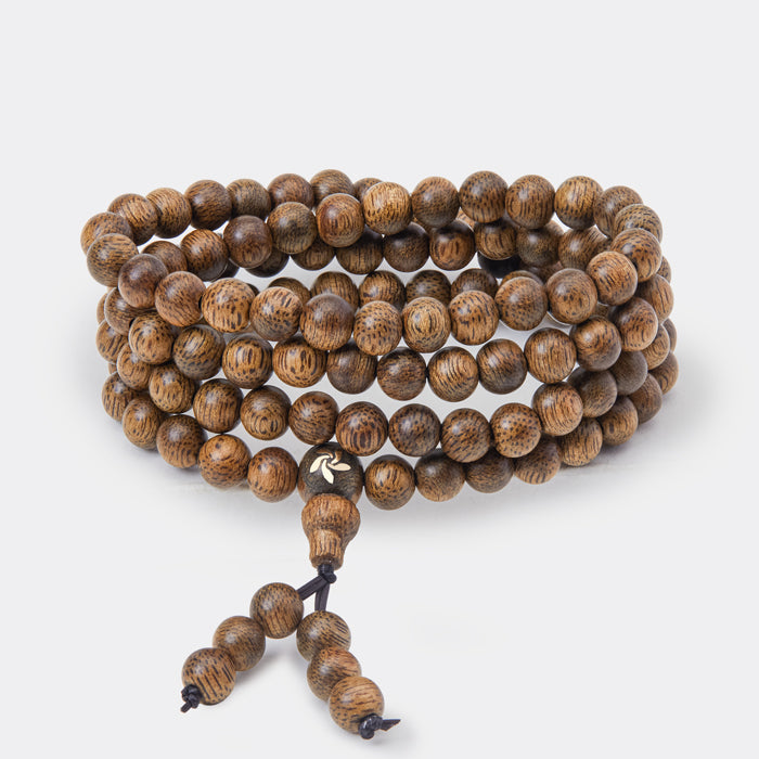 Bracelet composé de 108 perles en bois d’agar naturel avec incrustation en or 14 carats.