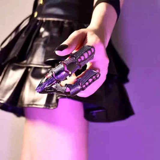 Longues griffes métalliques aux textures cybernétiques et segments mobiles.