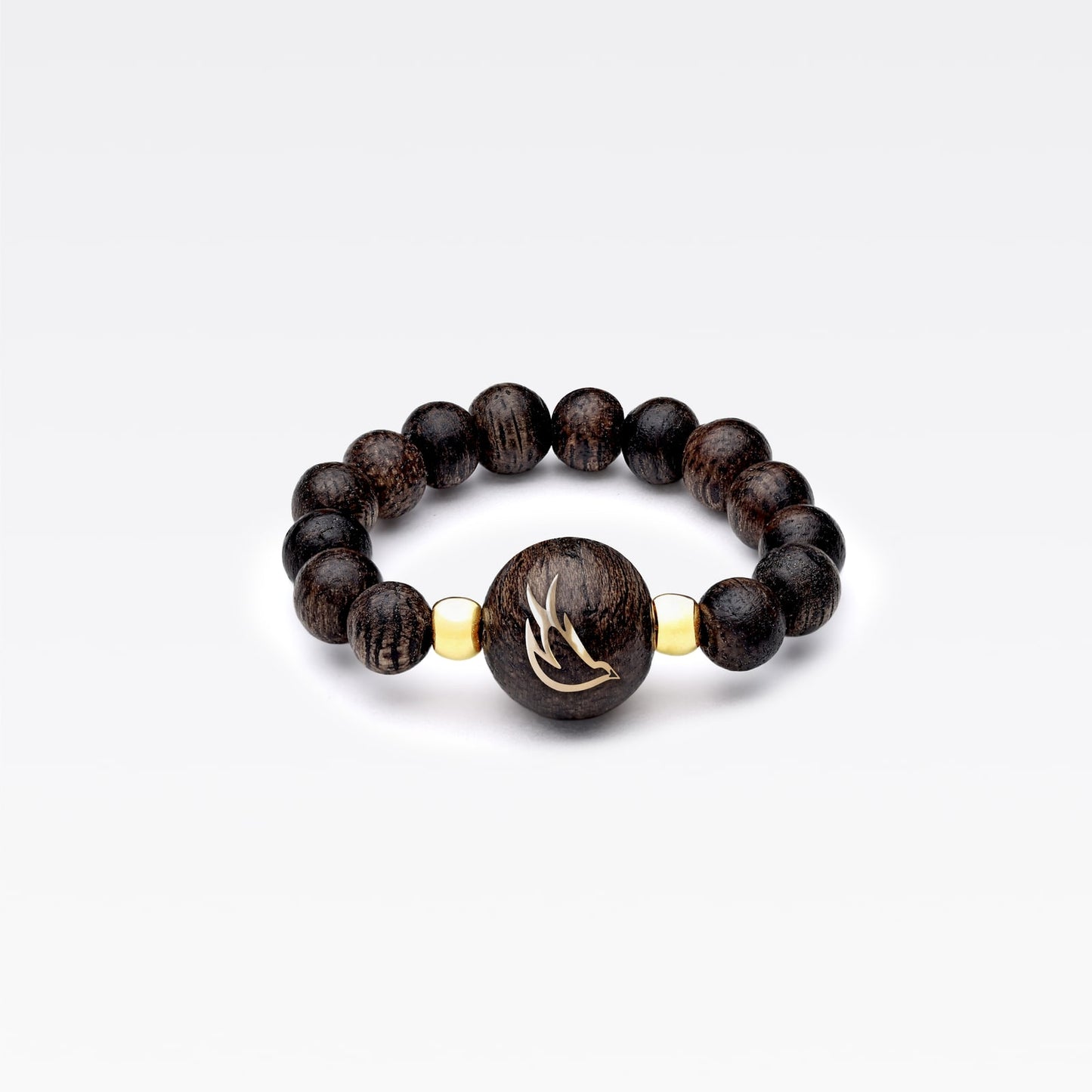 Bague en bois d’agar avec perle centrale incrustée d’or à motif symbolique.