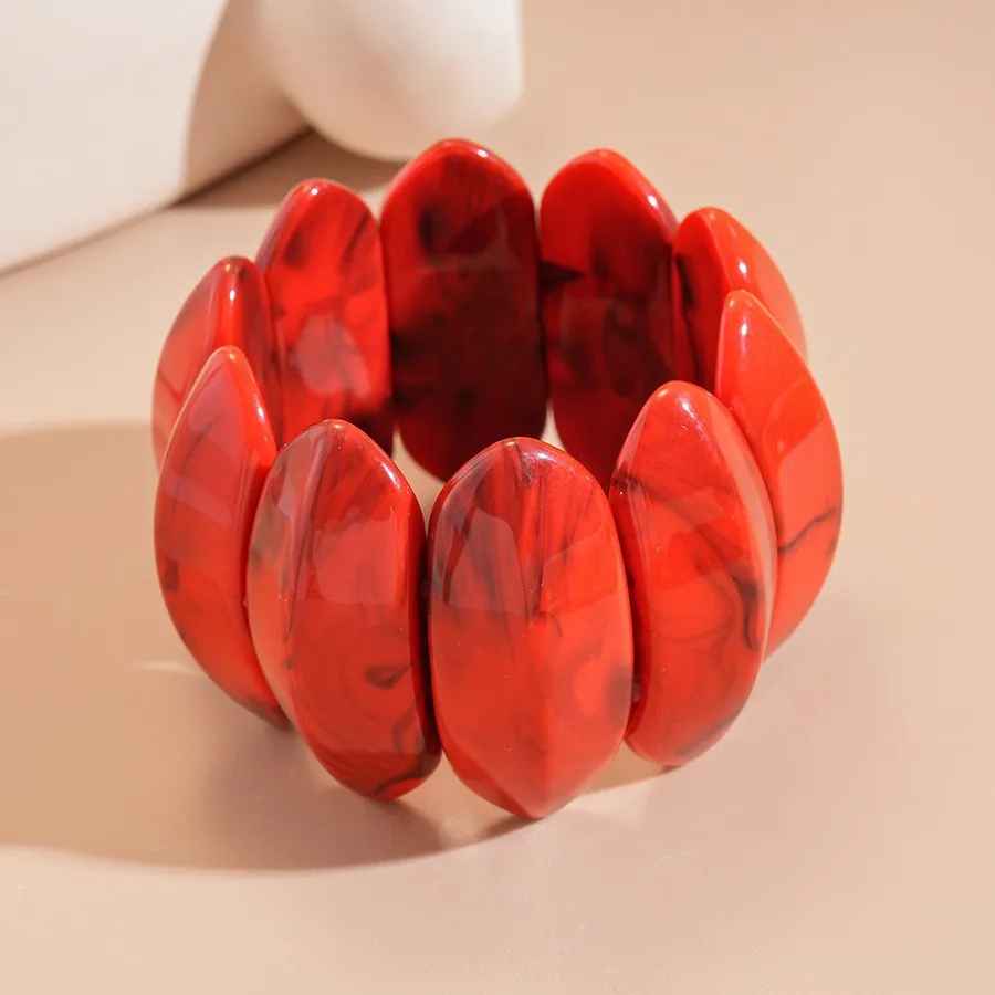 Bracelet couleur ambre aux courbes douces et à l’aspect brillant.