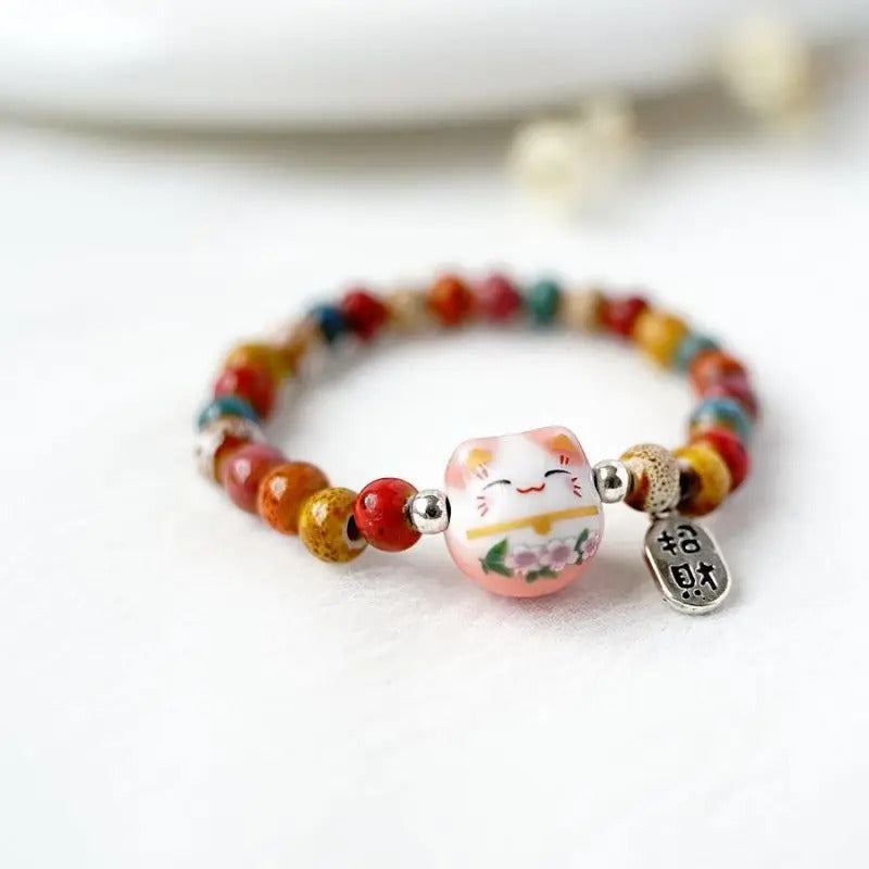 Bijou de poignet coloré avec chat porte-bonheur japonais, conçu pour garder une intention positive près de soi.