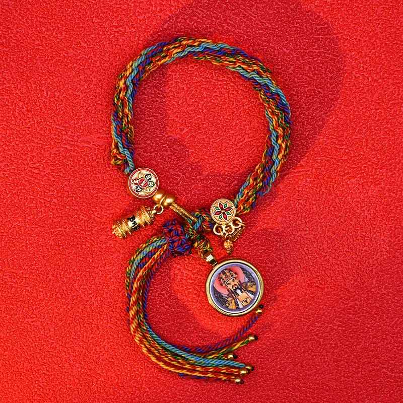 Bracelet tissé avec fils colorés et petite breloque symbolique dorée.