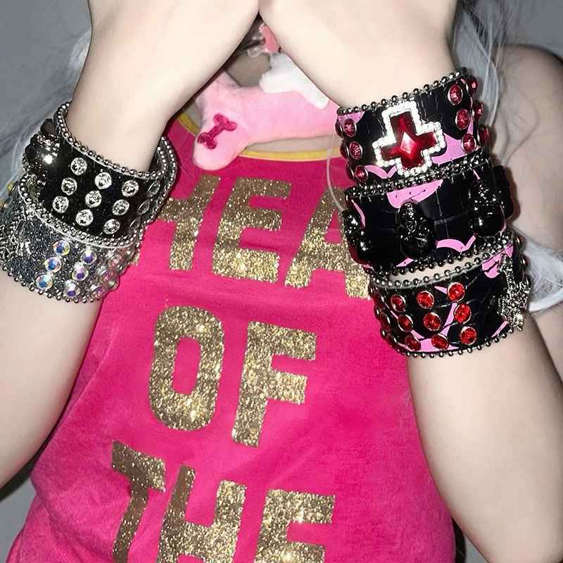 Poignet orné de plusieurs bracelets Batcave aux strass et détails colorés.