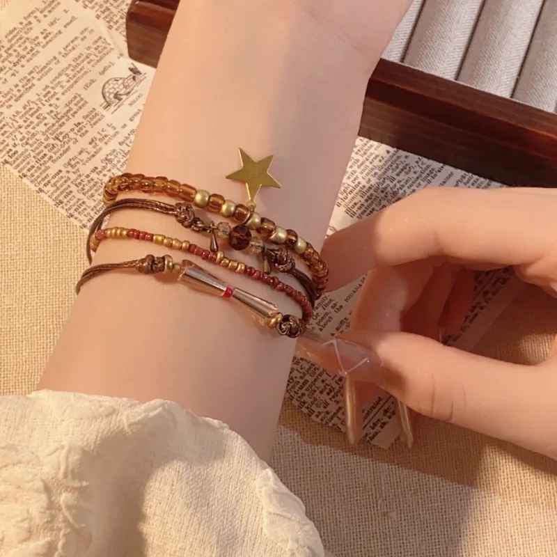 Bracelets fins dorés et marron avec charms métalliques vintage.