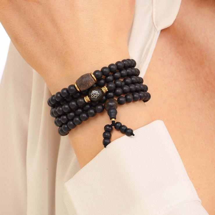 Système de fermeture par cordon avec perles terminales sur bracelet en bois d’agar.