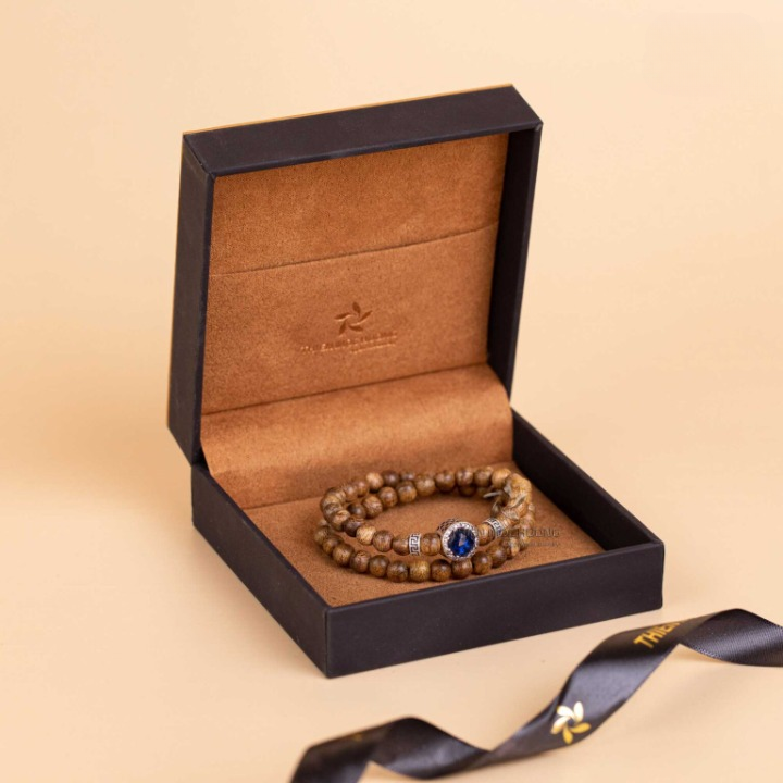 Association du bois d’agar et d’un charm en argent S925, créant un contraste élégant.