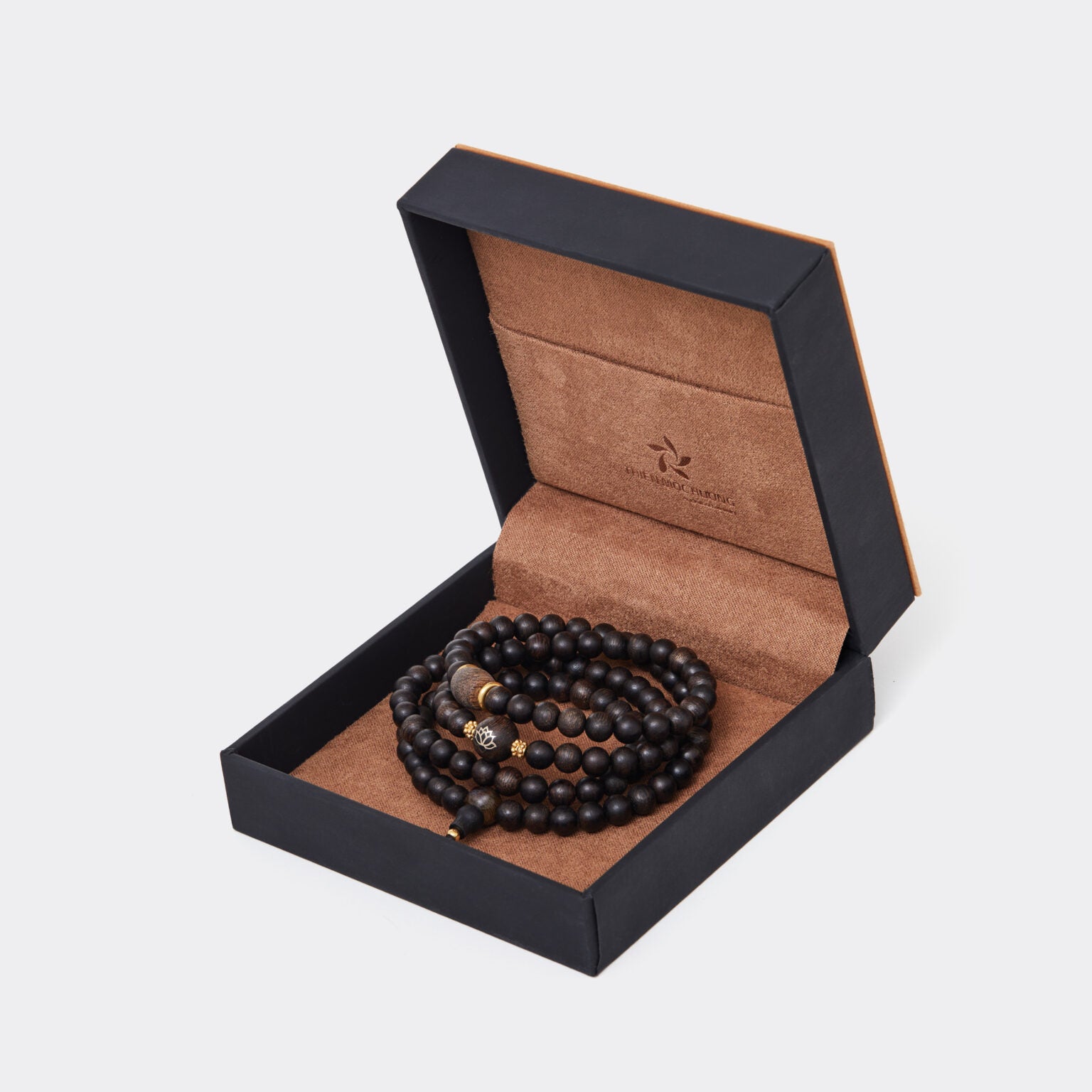 Détails des éléments décoratifs en or 9999 intégrés au bracelet en bois d’agar.