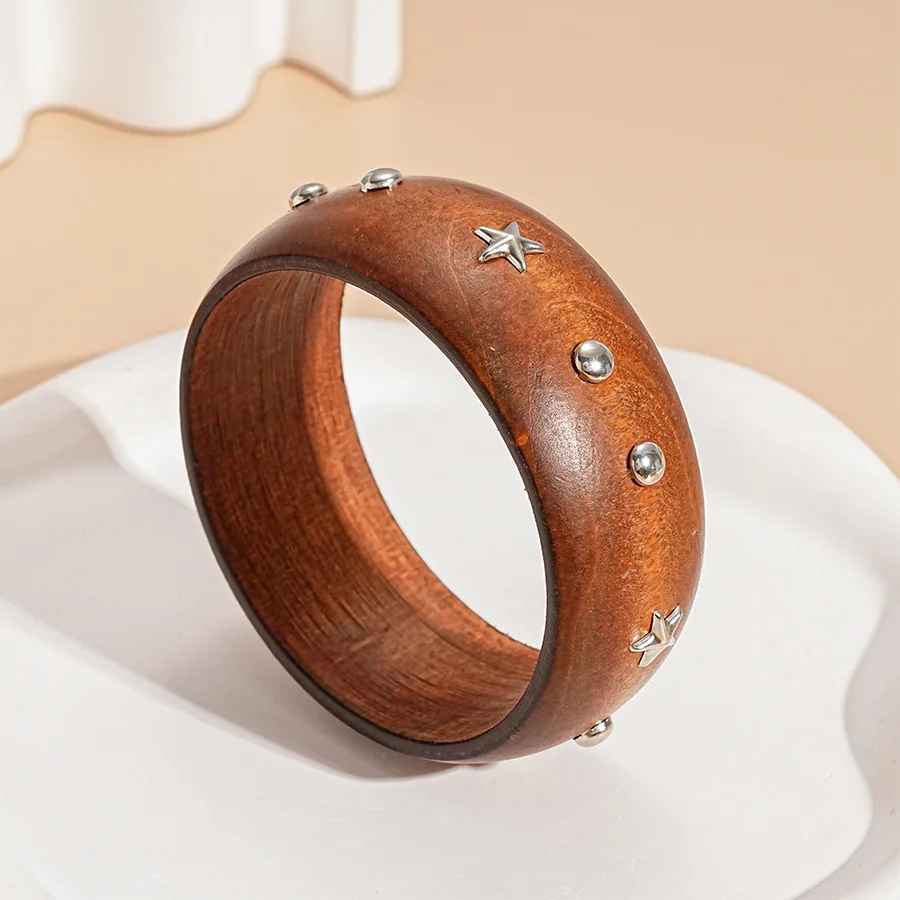 Bracelet en bois naturel aux lignes sculptées, avec une finition lisse qui met en valeur la richesse de la matière.