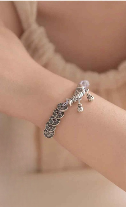 Gros plan sur la carpe Koi en argent 999 montrant le poinçon gravé sur le fermoir du bracelet.