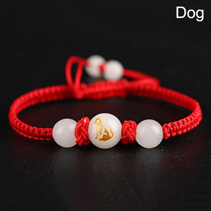 Bracelet Feng Shui rouge avec médaillon du Chien, symbole de loyauté et d’harmonie.