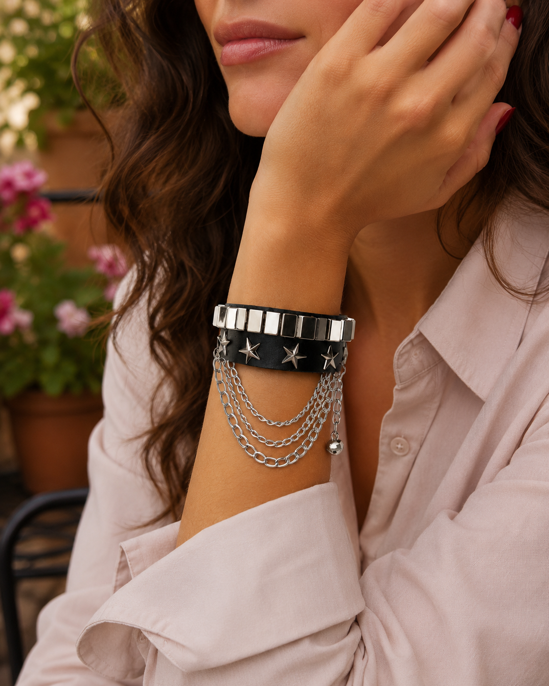 Bracelet en cuir noir décoré d’étoiles en métal et de chaînes superposées. Son design travaillé apporte une touche punk intense au poignet.