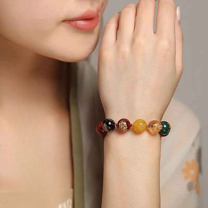 Bracelet en grosses perles rouges disposé sur fond assorti, évoquant une énergie Yang intense et chaleureuse.