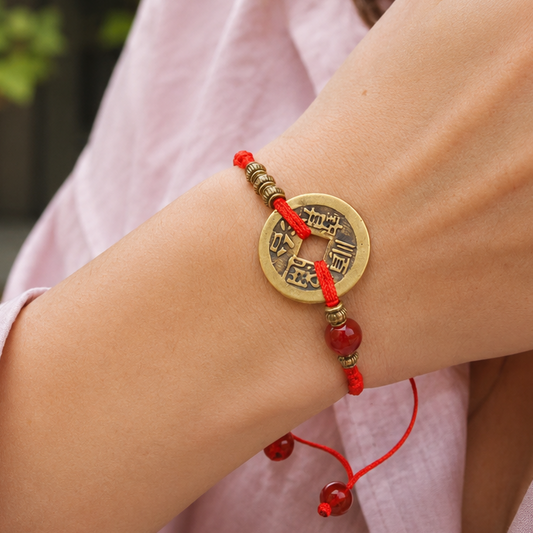 Bracelet Feng Shui avec sapèque ancienne et cordon tressé, pensé comme un talisman élégant pour accompagner chance et prospérité au quotidien.