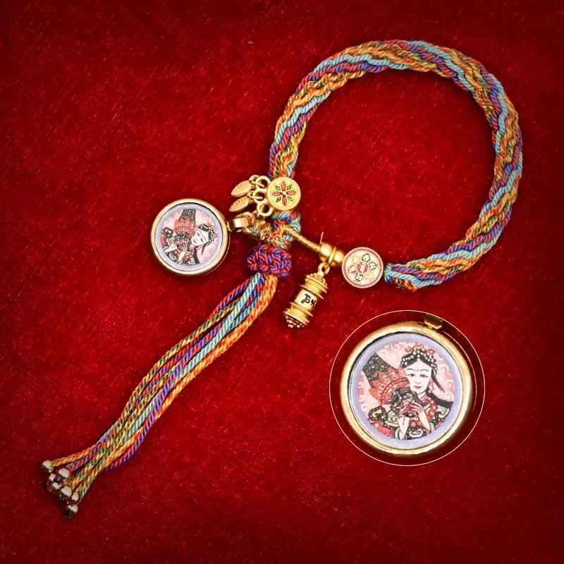 Tissage en coton multicolore associé à un pendentif protecteur en métal doré.