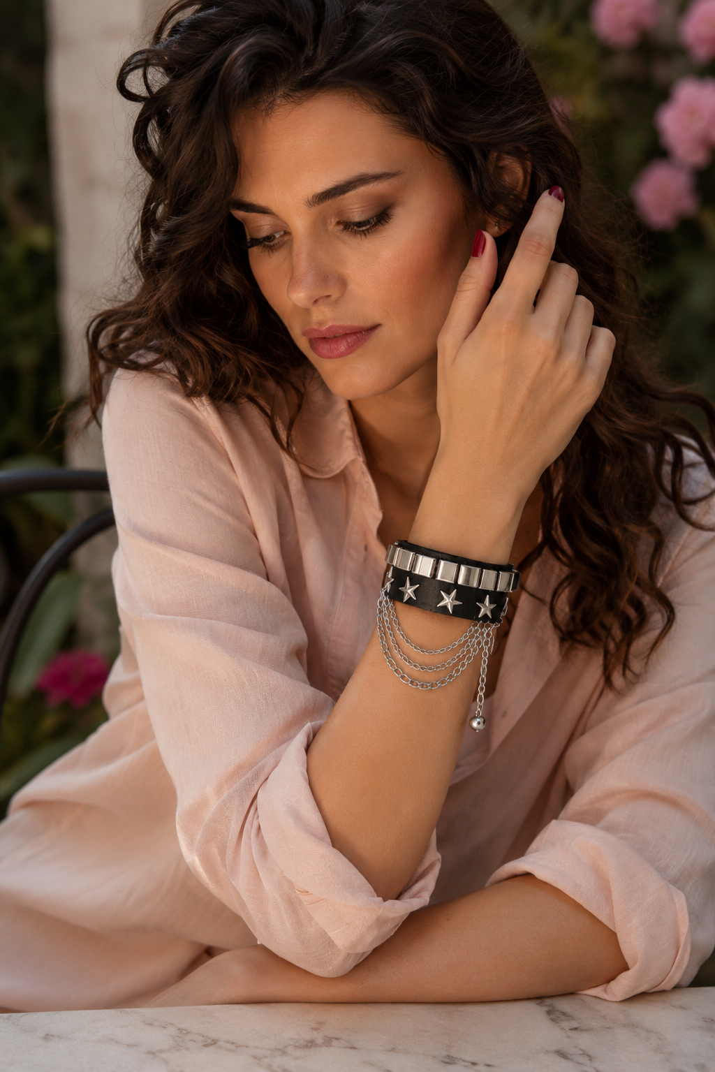 Bracelet gothique avec chaînes pendantes et étoiles en relief. Les détails métalliques créent un contraste puissant avec le cuir.