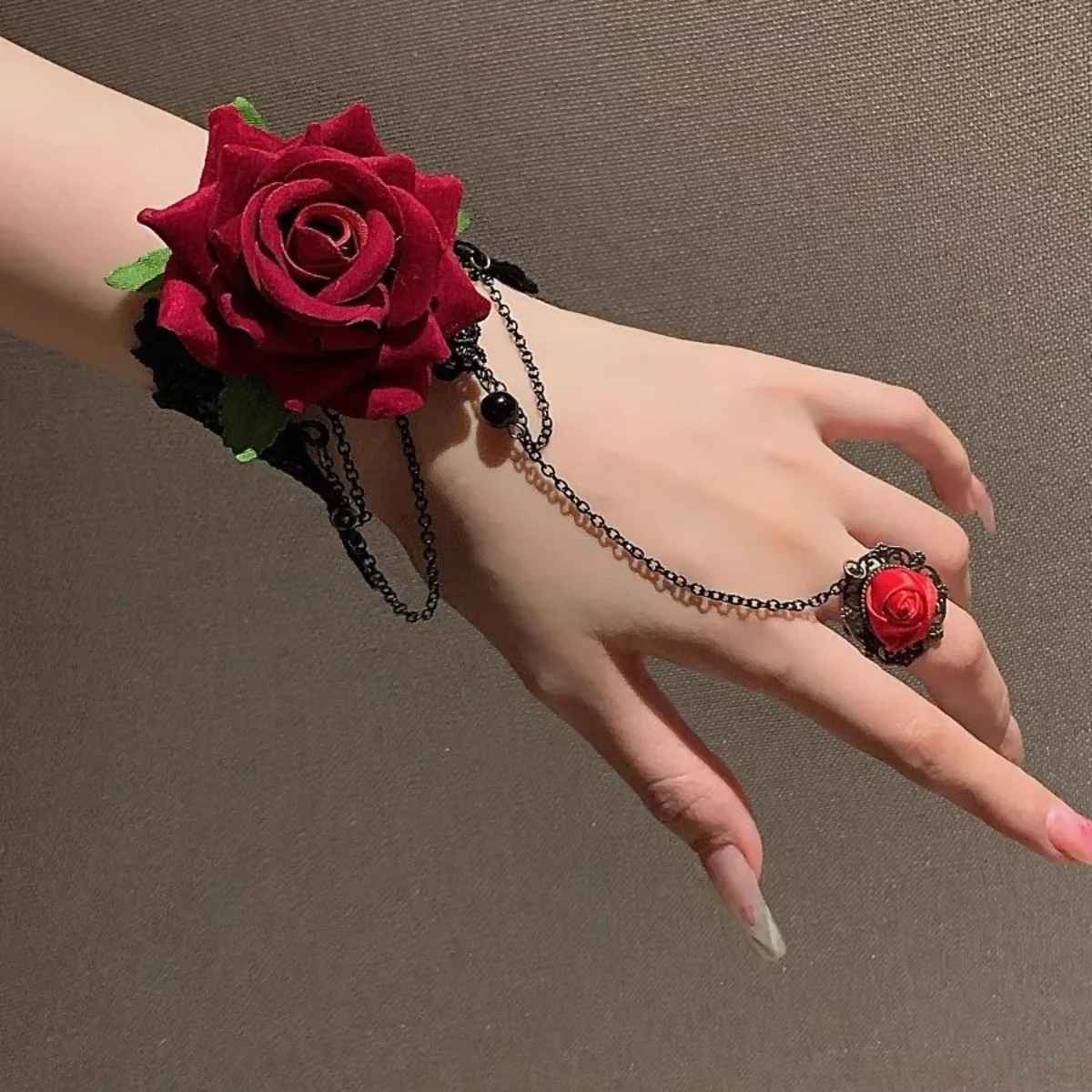 Bracelet gothique lolita en dentelle noire avec grande rose rouge et chaînes décoratives.