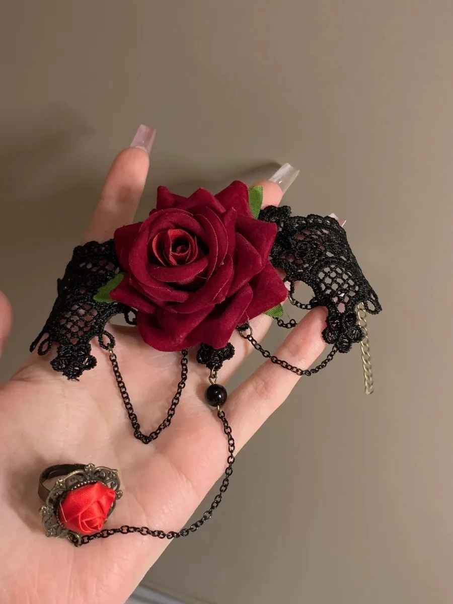 Vue détaillée de la rose rouge centrale et de la dentelle noire aux motifs victoriens.