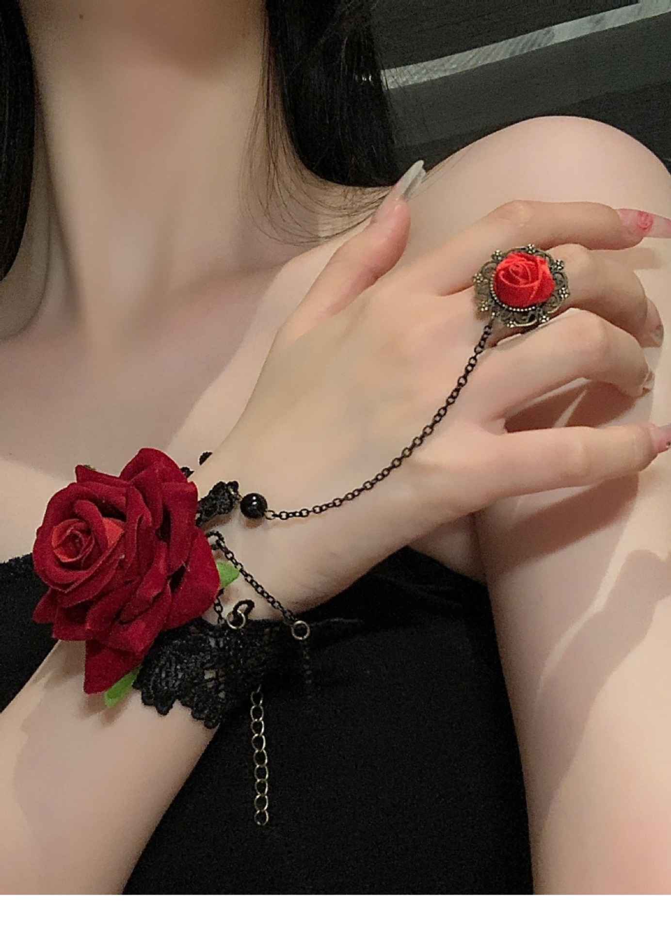 Bracelet porté sur la main avec chaînes pendantes et bague ornée d’une rose miniature.