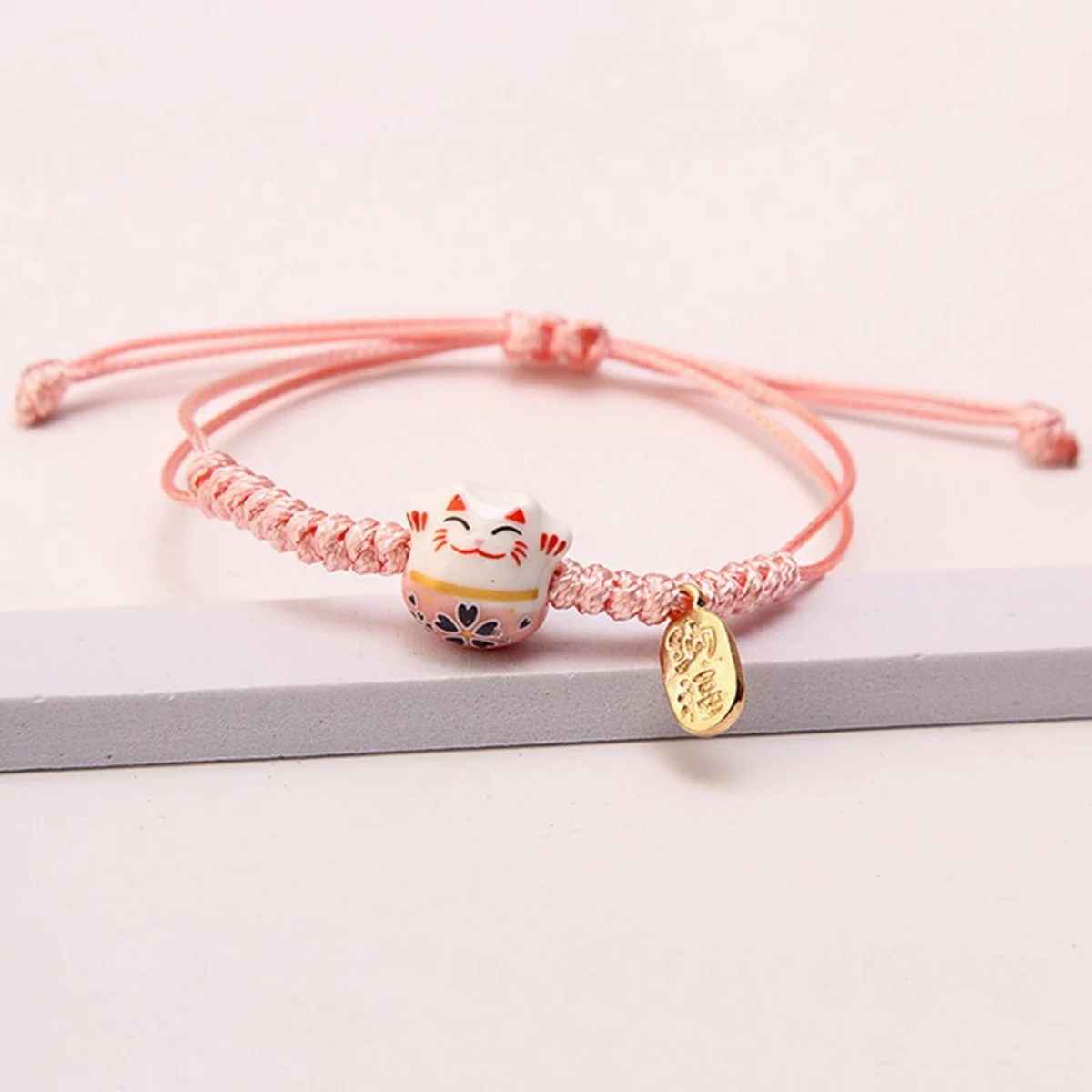 Bracelet japonais porte-bonheur avec Maneki Neko, symbole de joie et de fortune.