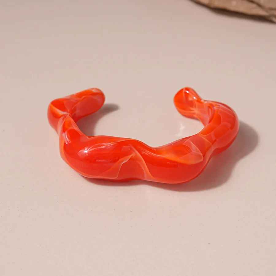 Bracelet large en résine brillante, silhouette arrondie.