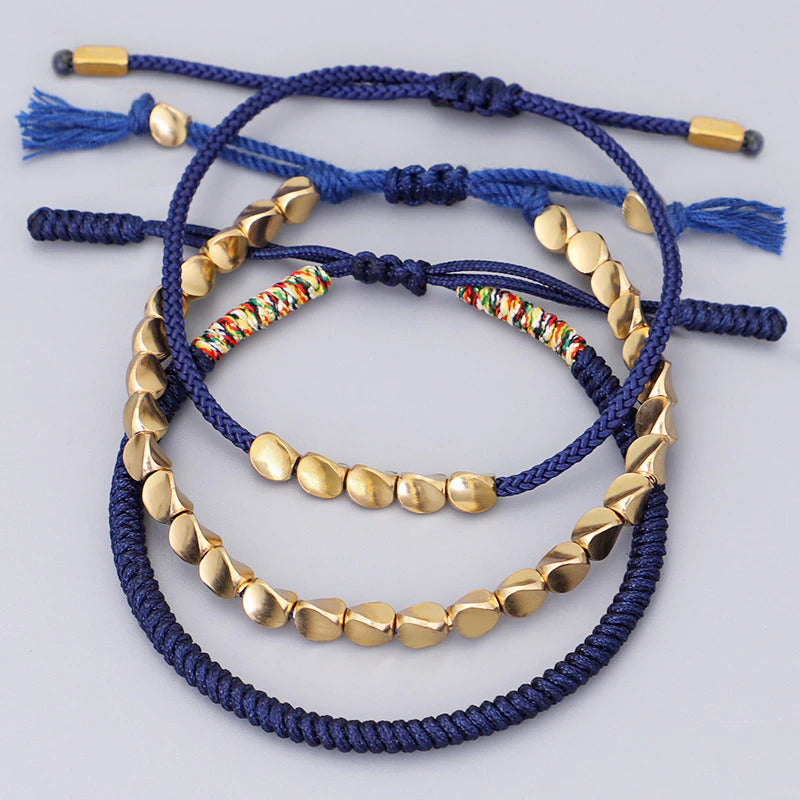Bracelet artisanal ajustable en macramé bleu foncé avec perles de cuivre poli.
