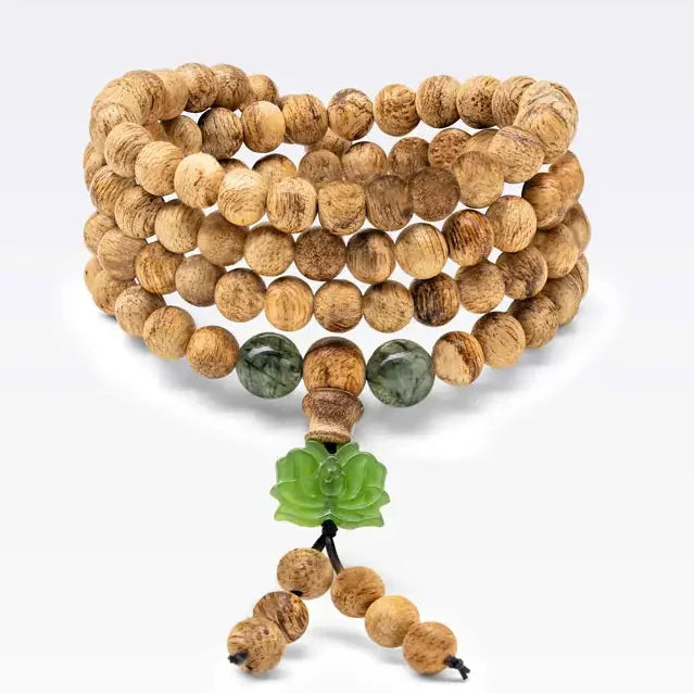 Bracelet mâlâ 108 perles en bois d’agar avec charm lotus en pierre naturelle. Le format est conçu pour se porter en plusieurs tours.