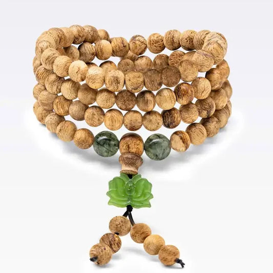 Bracelet mâlâ 108 perles en bois d’agar avec charm lotus en pierre naturelle. Le format est conçu pour se porter en plusieurs tours.