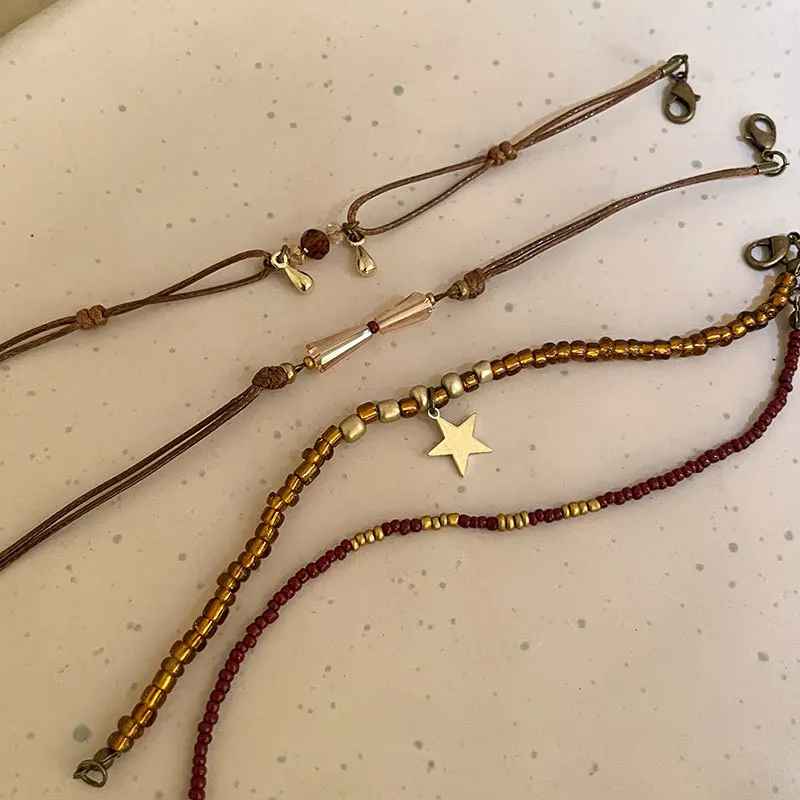 Bracelets multicouches en cristal marron portés au poignet, tons chauds.