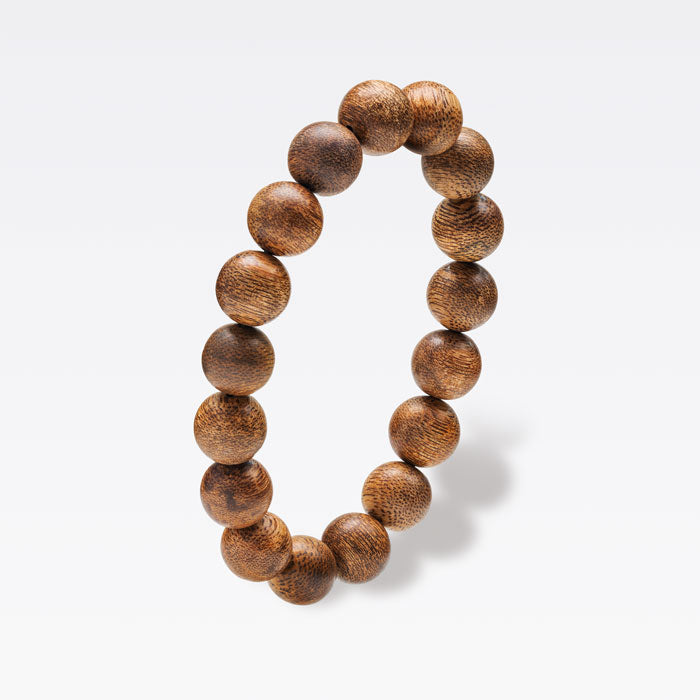 Perles de bois d’agar naturel présentant des variations subtiles de texture et de teinte.