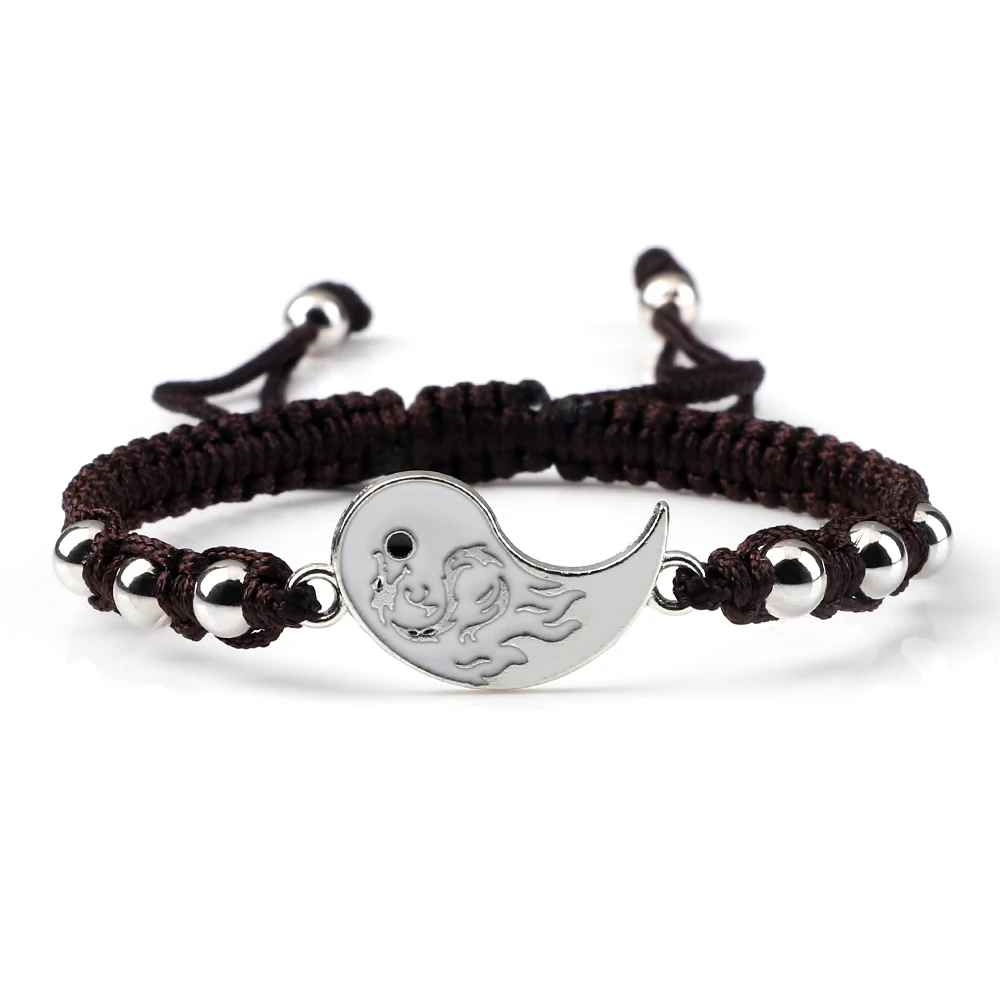 Perles métalliques polies qui captent la lumière et soulignent le relief du tressage.