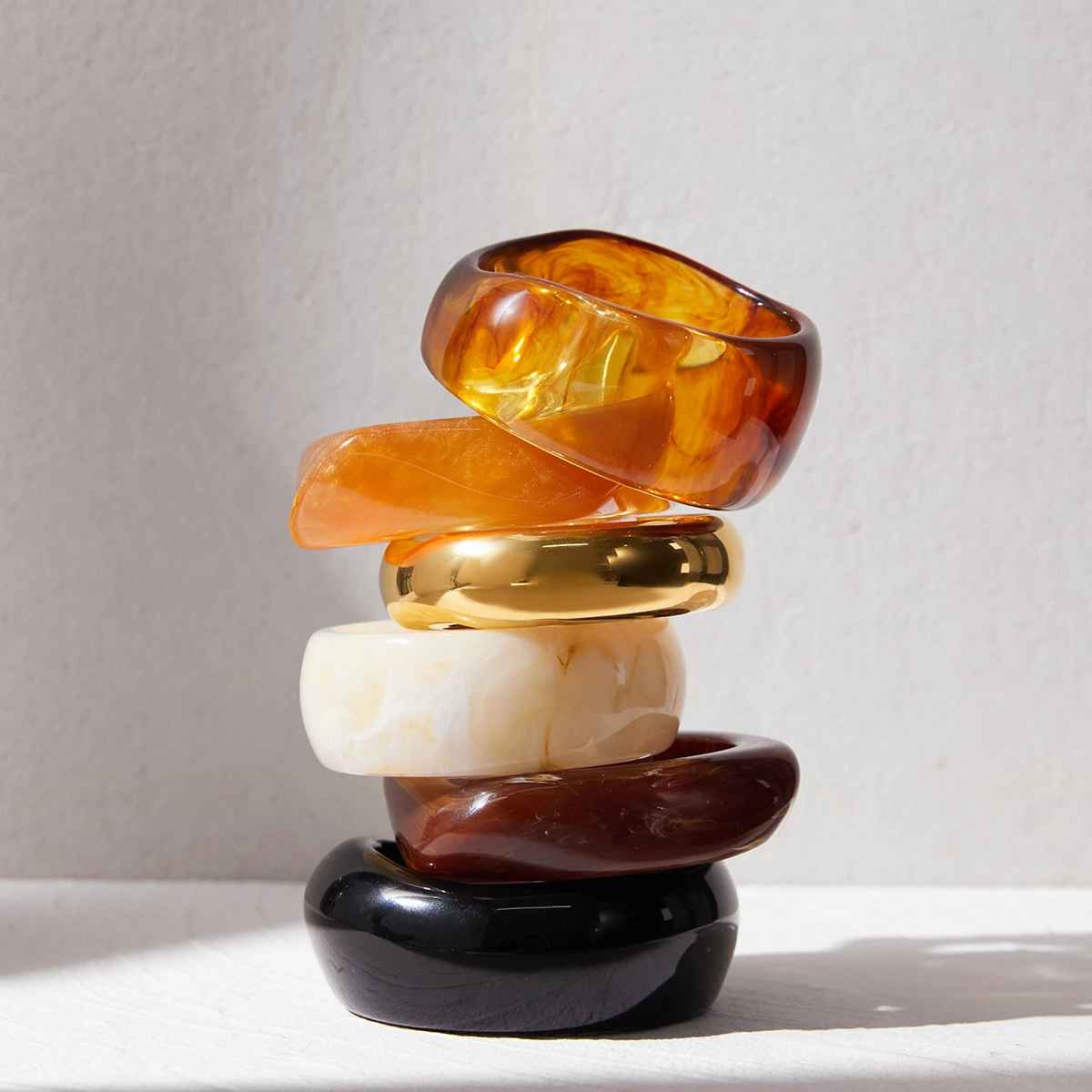 Bracelet épais en résine ambre avec indication des dimensions et finition brillante, style moderne.