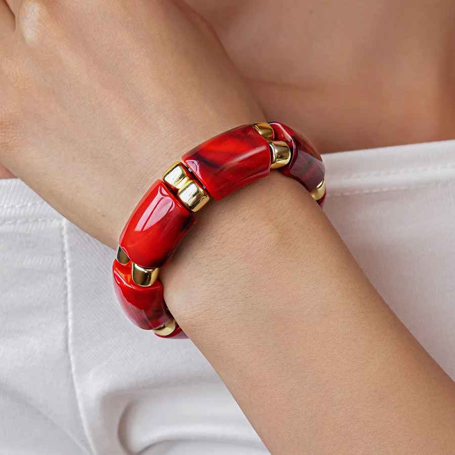 Bracelet en résine noire aux contours arrondis et au style contemporain.