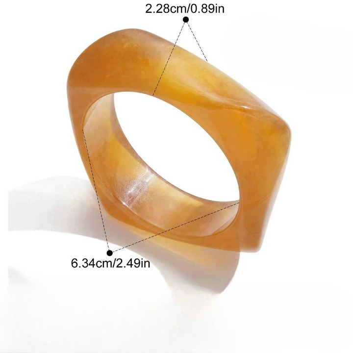 Bracelet en résine noire porté avec tenue minimaliste crème, pour un style moderne et casual chic.