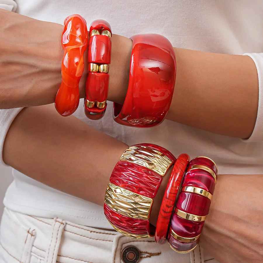 Bracelet rigide large en résine, idéal pour donner du caractère à une tenue. Son aspect poli capte la lumière avec douceur.