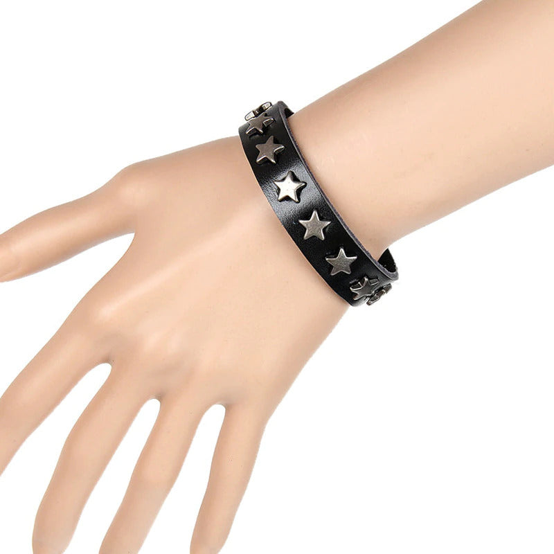 Bracelet en cuir noir porté au poignet, au design punk chic et unisexe.