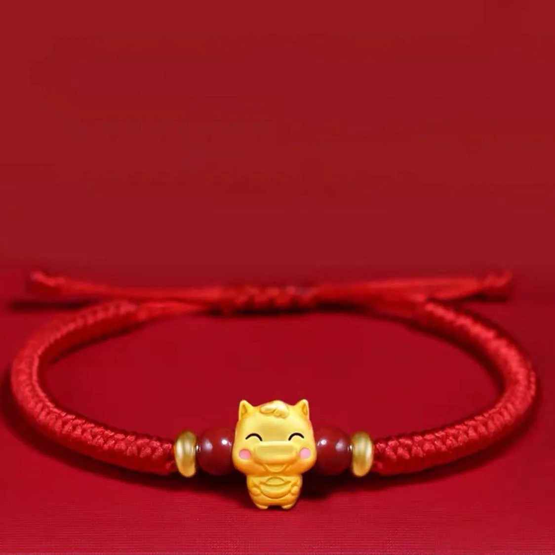 Bracelet signe Cheval avec perles rouges et séparations dorées. Le réglage coulissant facilite le port au quotidien.