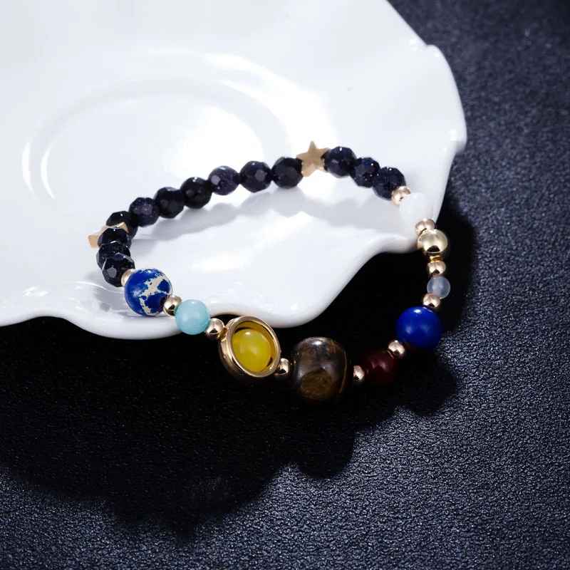 Bracelet fait main inspiré du système solaire, orné de perles planétaires et dorées.
