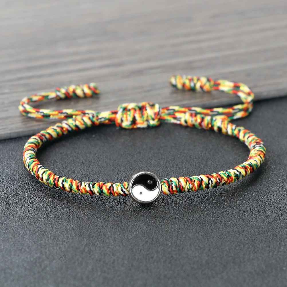Bracelet macramé multicolore avec médaillon Yin Yang au centre et nœud coulissant de réglage.