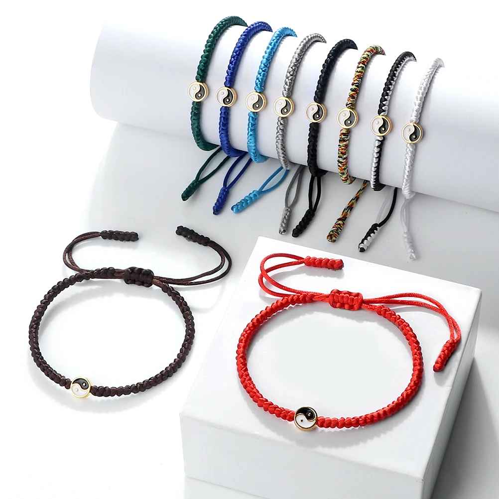 Bracelets macramé avec médaillon Yin Yang noir et blanc cerclé métal, présenté sur fond sombre.
