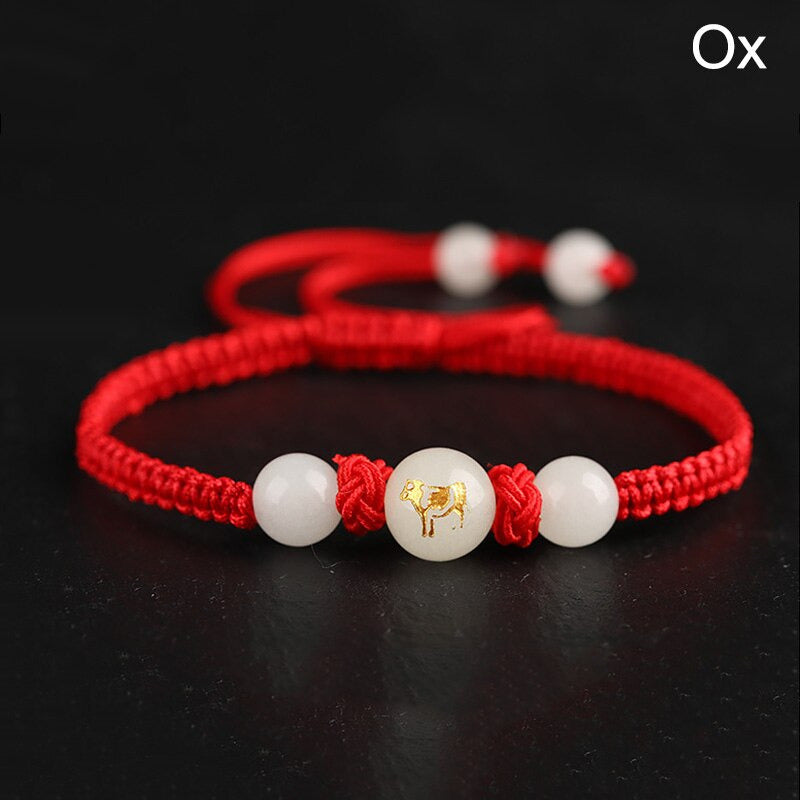 Bracelet unisexe Feng Shui ajustable en macramé rouge artisanal. Représentation du boeuf, ou de la vache.