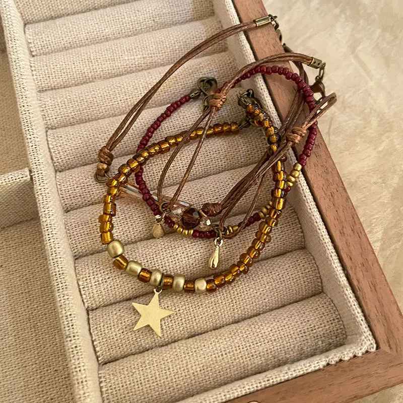 Ensemble de bracelets marron avec perles ambrées et cordons ajustables.