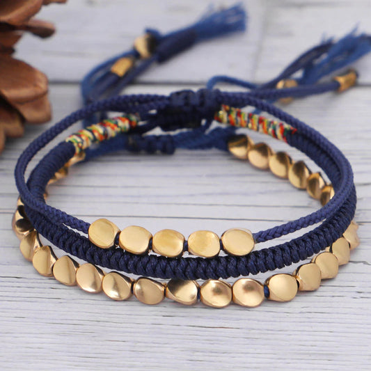 Ensemble de bracelets tibétains en cuivre et corde bleue tressée, style boho-chic artisanal.